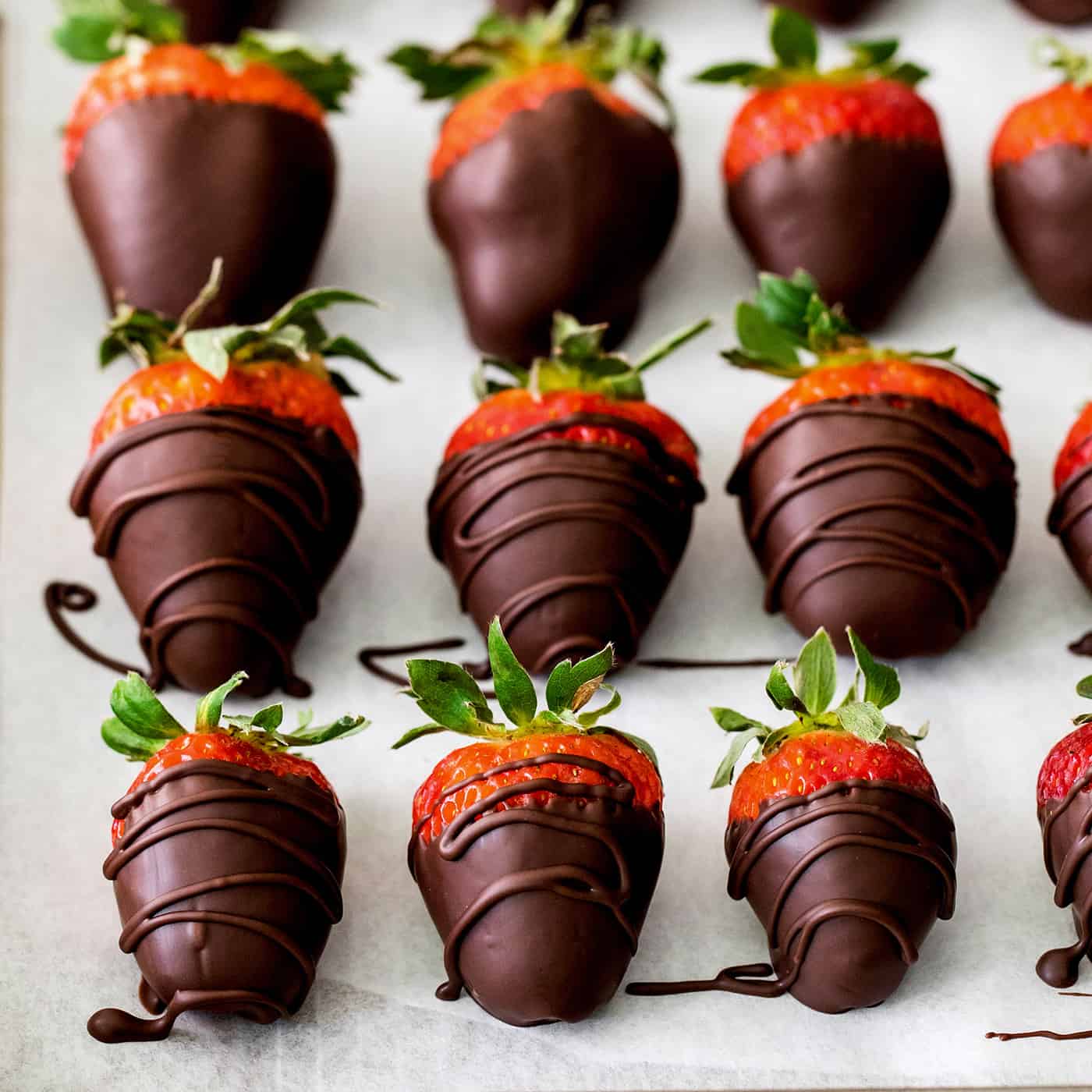 Overhead view of chocolate covered strawberries on a baking sheet