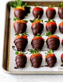 Overhead view of chocolate dipped strawberries on a baking sheet