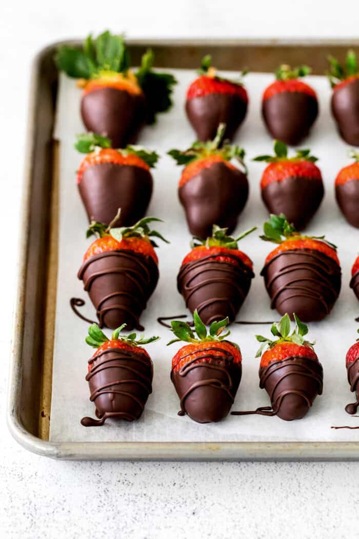 Overhead view of chocolate dipped strawberries on a baking sheet