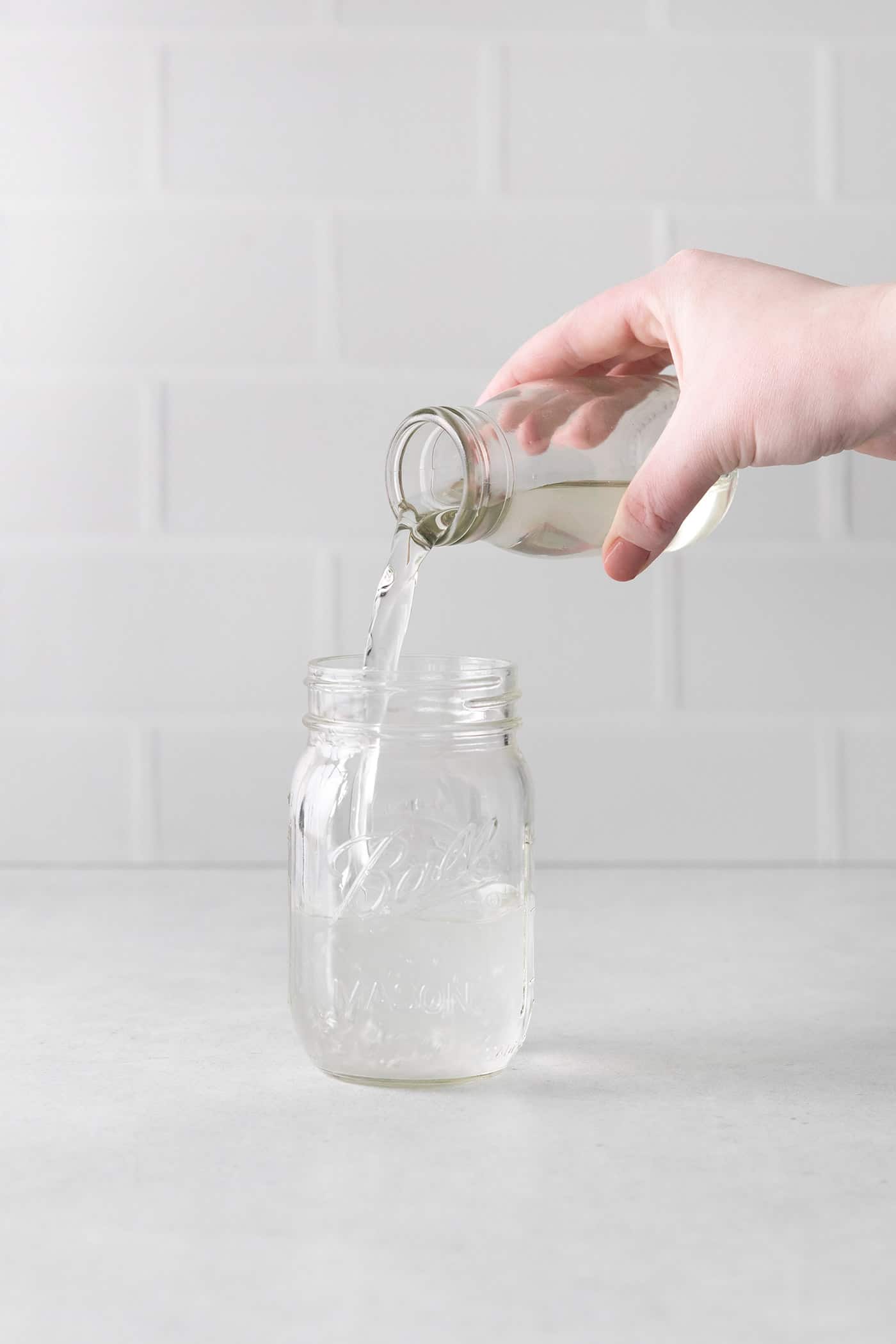 pouring simple syrup into a jar
