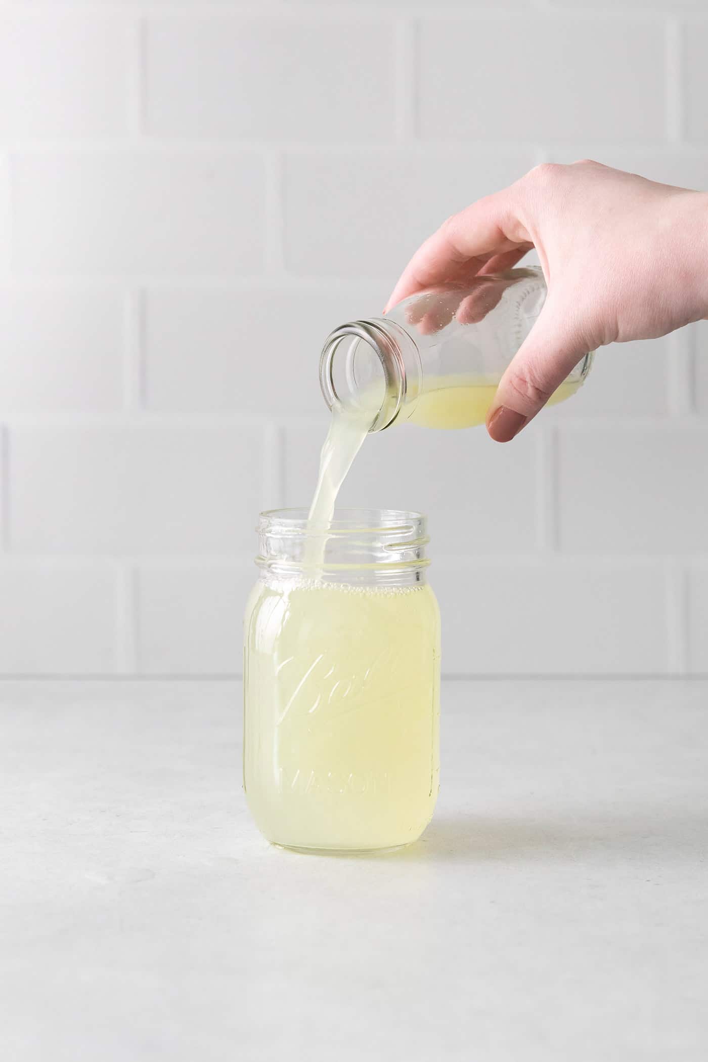 pouring lime juice into a jar