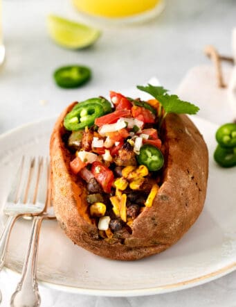 A taco stuffed sweet potato on a white plate