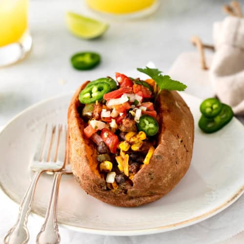 A taco stuffed sweet potato on a white plate