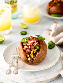 A taco stuffed sweet potato on a white plate