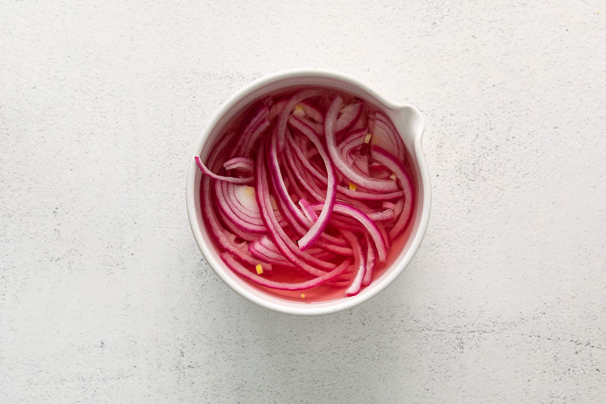 pickled red onions in a white bowl