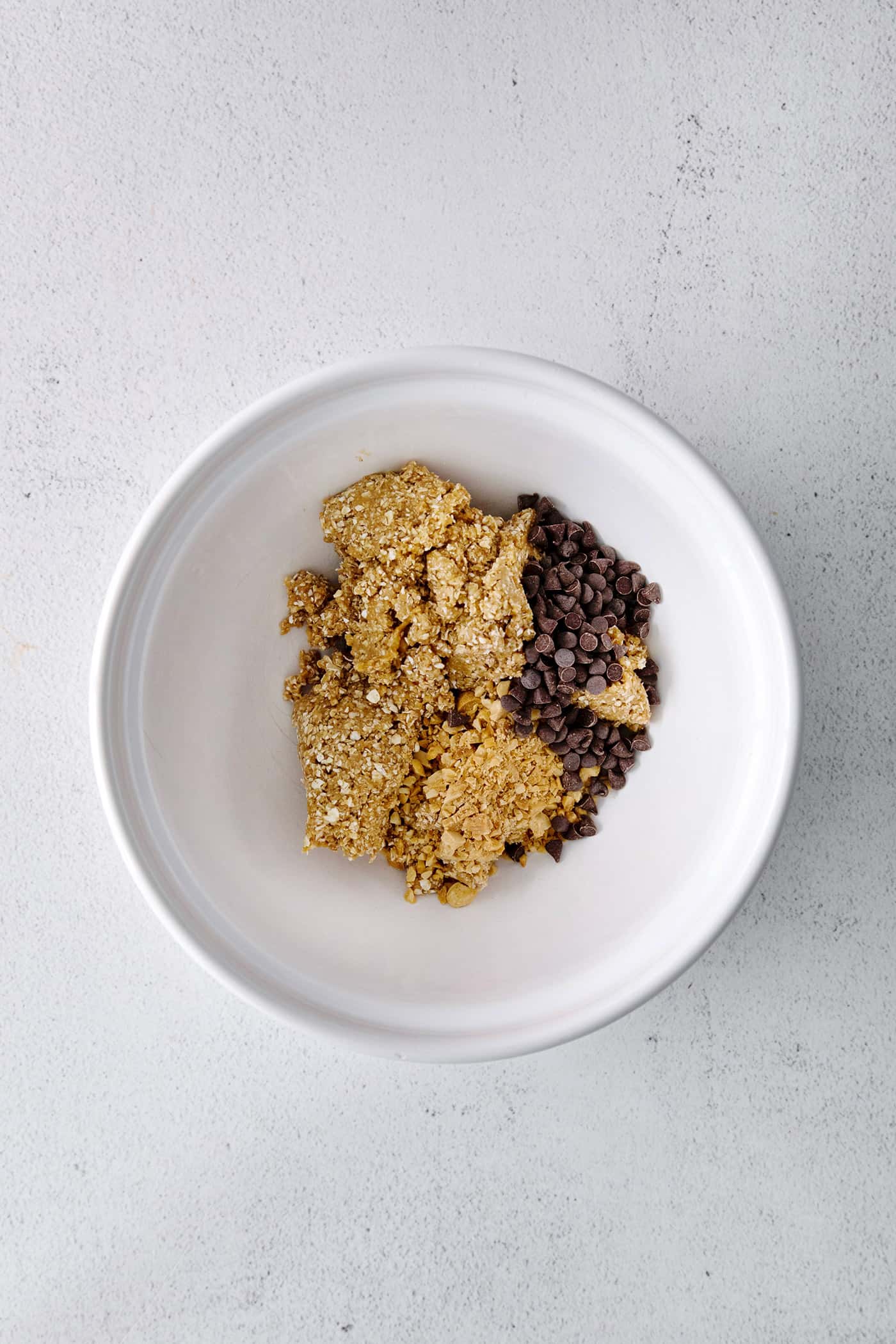 Peanut butter oat bites ingredients in a bowl with chocolate chips and nuts