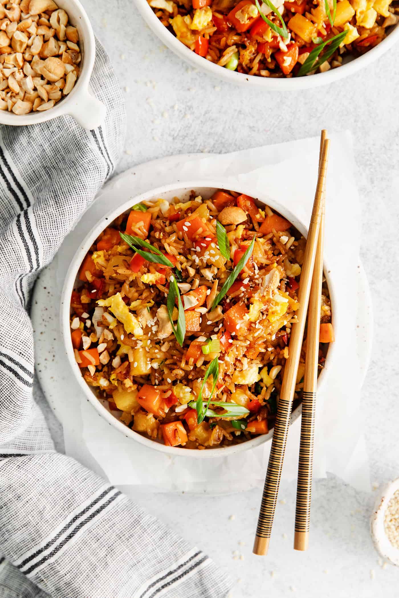 Overhead view of a bowl of pineapple fried rice with chopsticks resting on the bowl