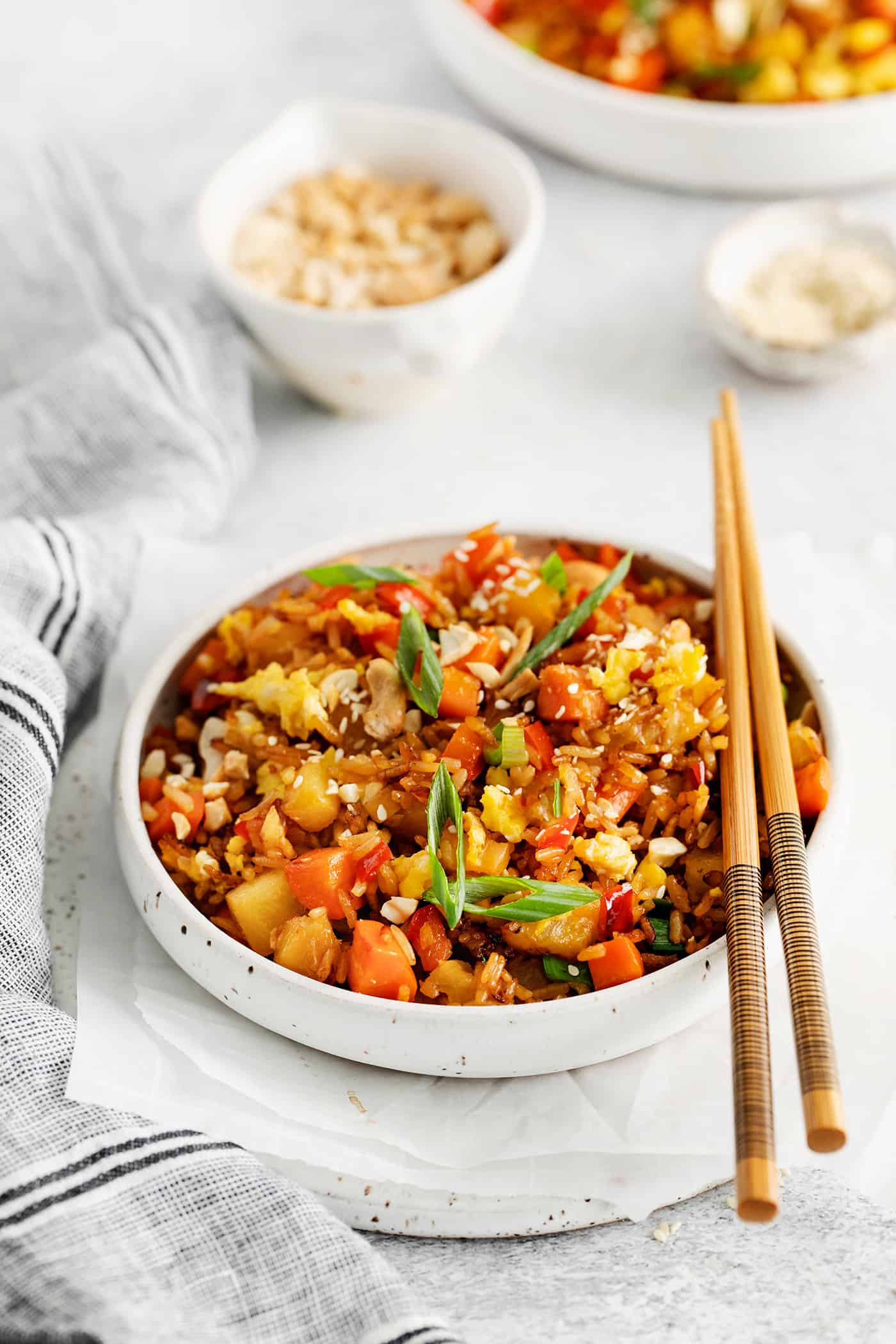 Angled view of a bowl of pineapple fried rice with chopsticks on the bowl