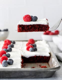 A spatula serving a slice of red velvet sheet cake