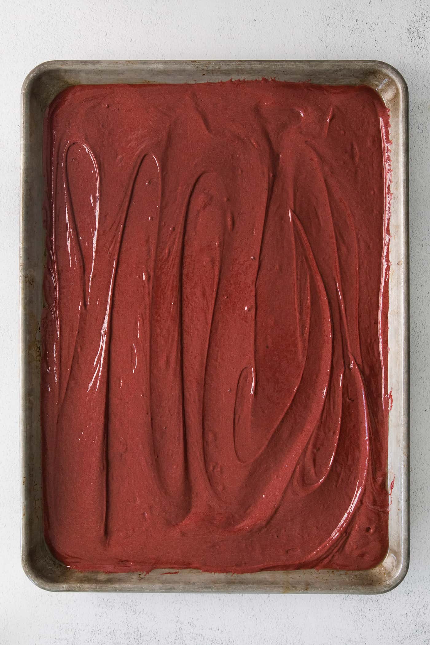Red velvet cake batter in a sheet pan