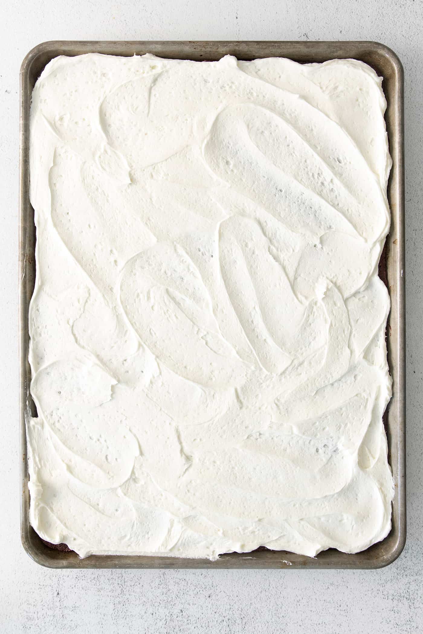 Cream cheese frosting spread on a sheet cake