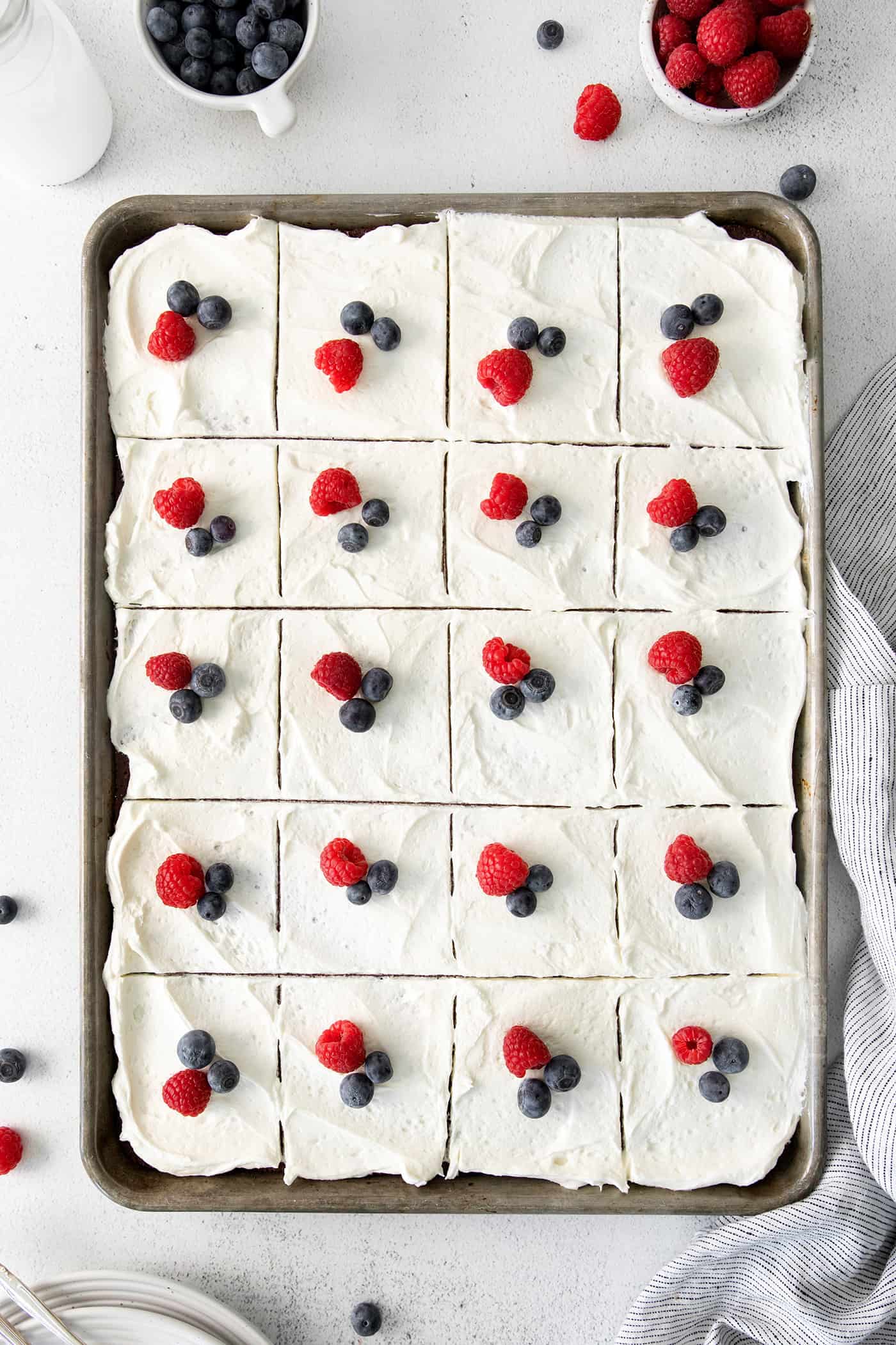 Berries on top of a sliced sheet cake