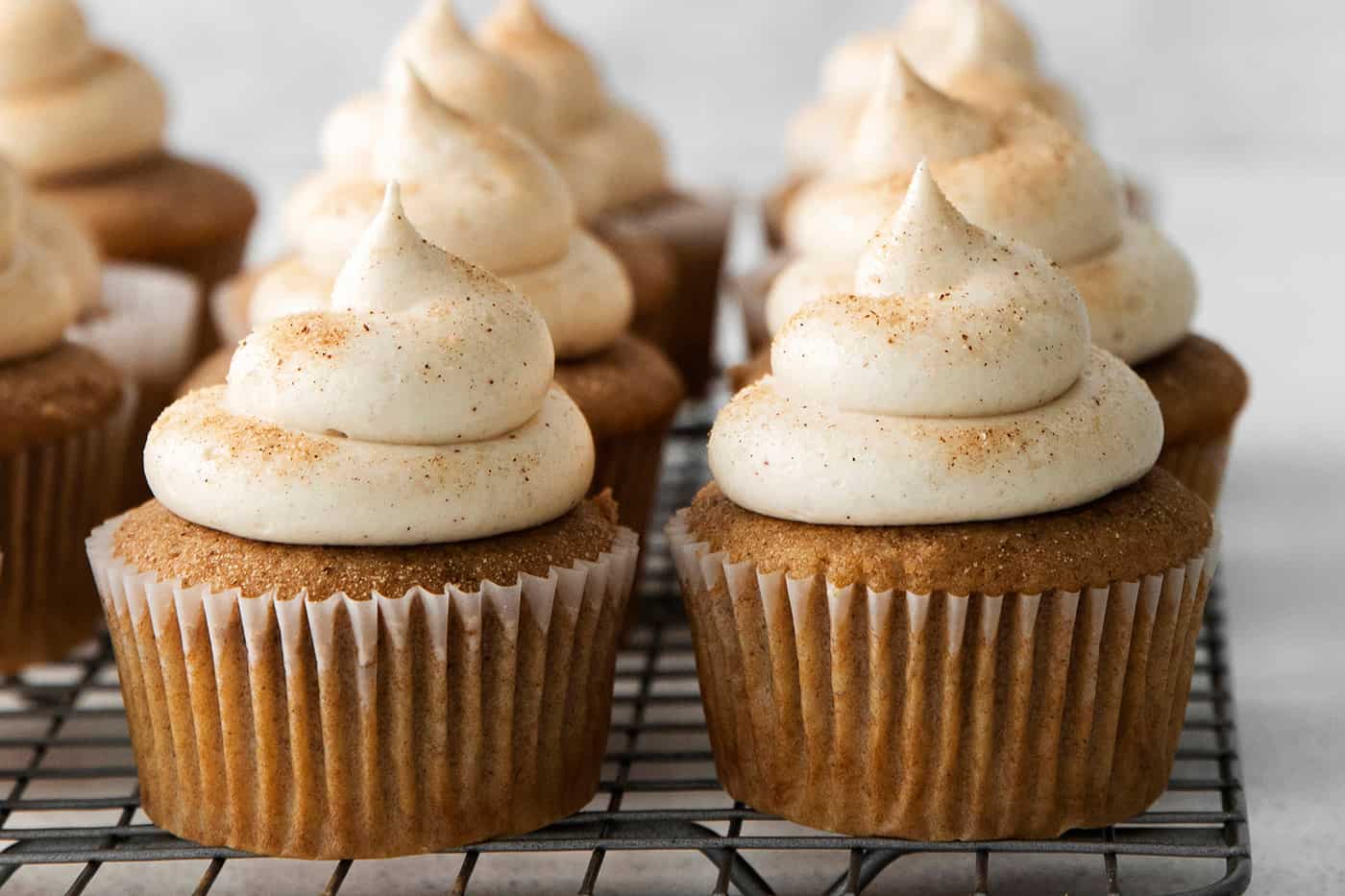 cinnamon cupcakes with cream cheese frosting sprinkled with cinnamon-sugar