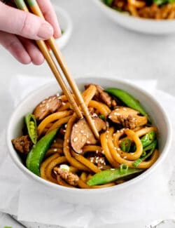 Chopsticks in a bowl of yaki udon with beef