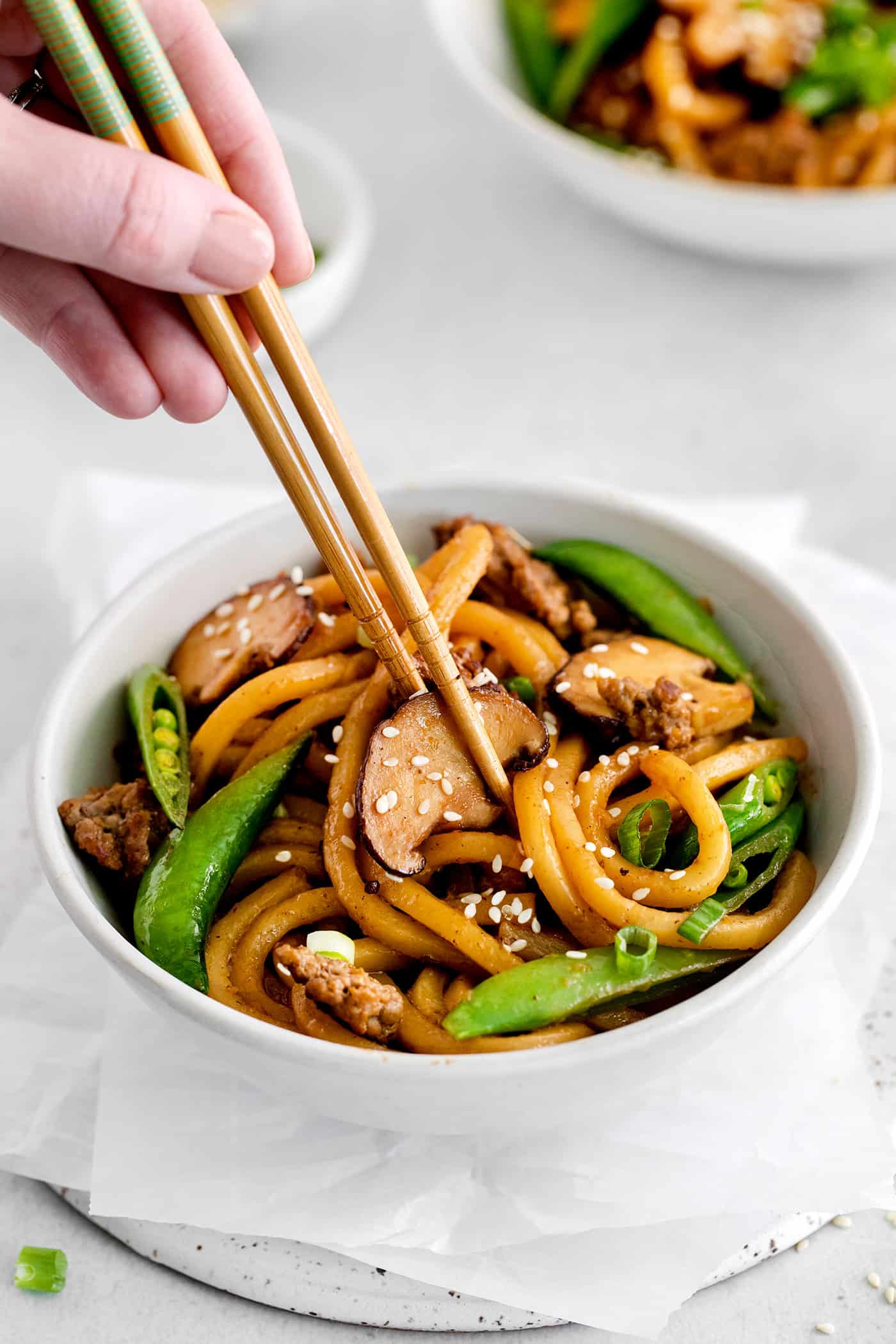 Chopsticks in a bowl of yaki udon with beef