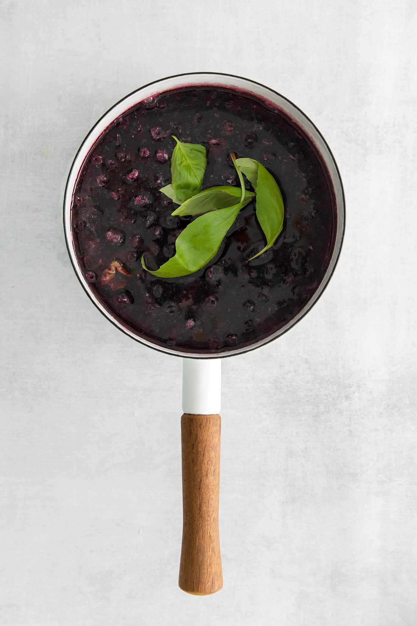Blueberry syrup with basil in a saucepan