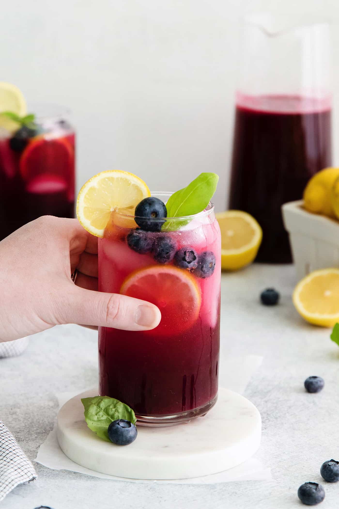 A hand holding a blueberry lemonade