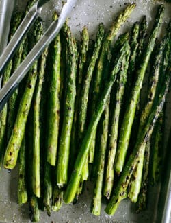 grilled asparagus on a rimmed pan