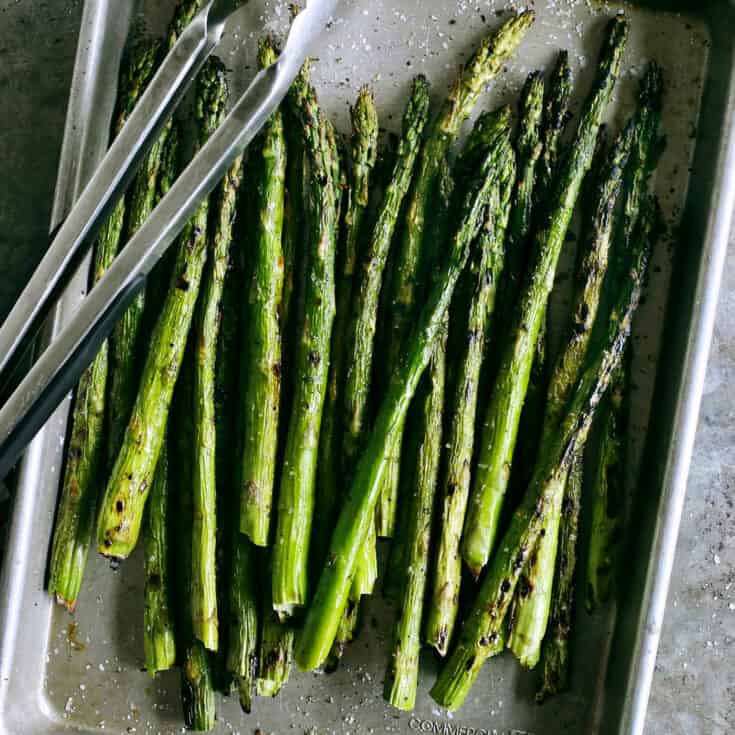 grilled asparagus on a rimmed pan