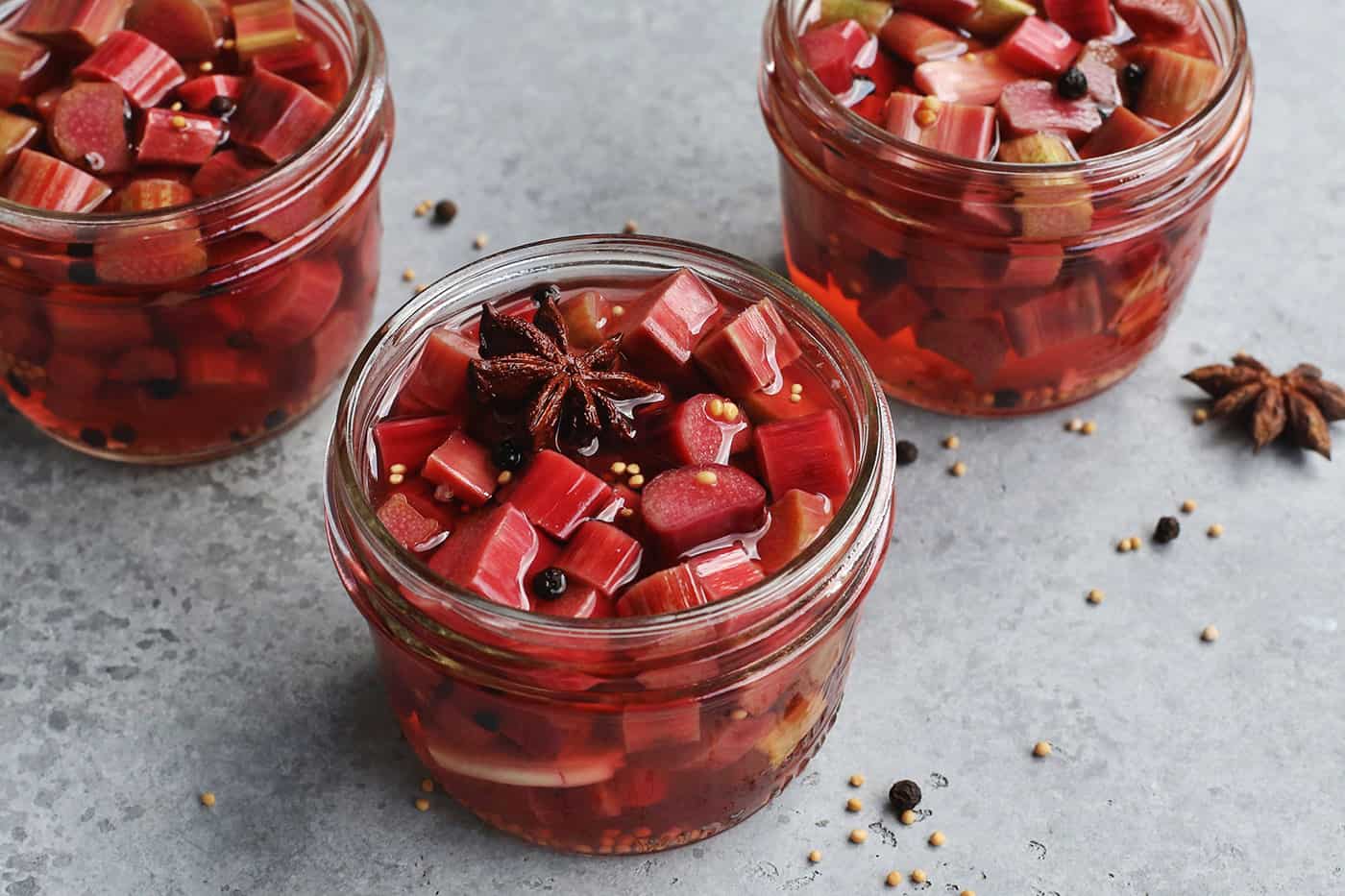 Angled view of three jars of pickled rhubarb