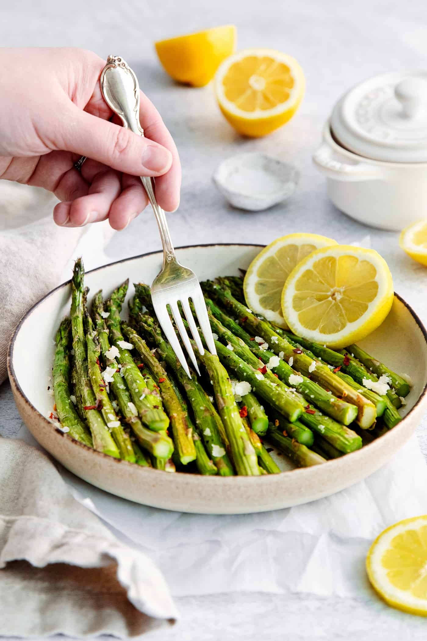 A fork diving into oven roasted asparagus