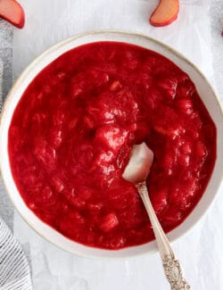 A bowl of rhubarb sauce with a spoon in it