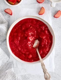 A bowl of rhubarb sauce with a spoon in it