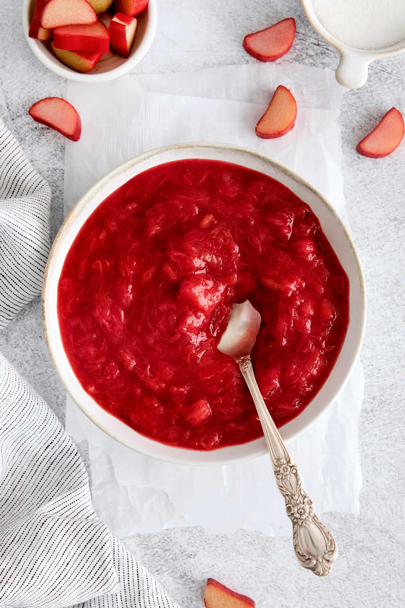 A bowl of rhubarb sauce with a spoon in it