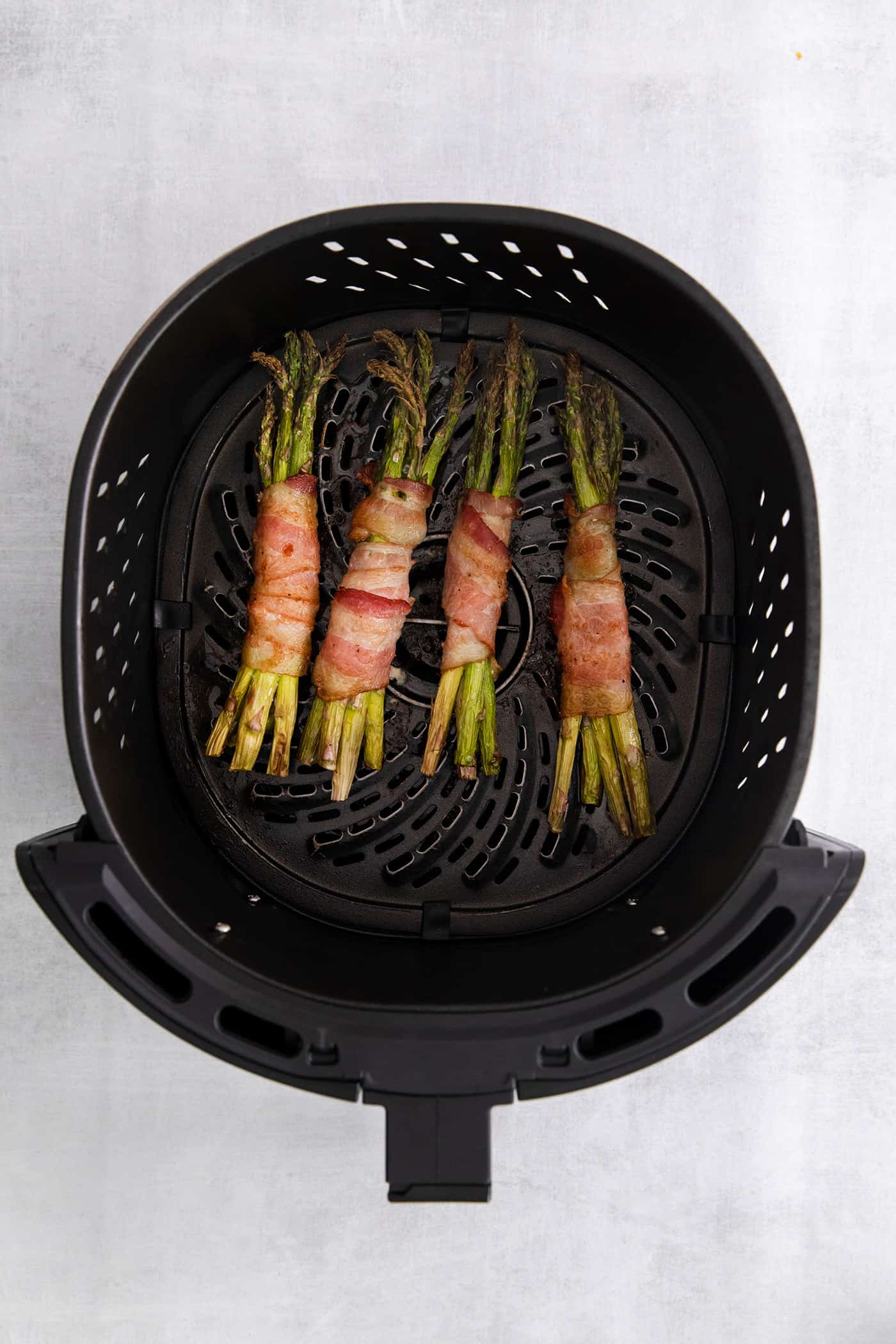 Overhead views of bacon wrapped asparagus in the air fryer