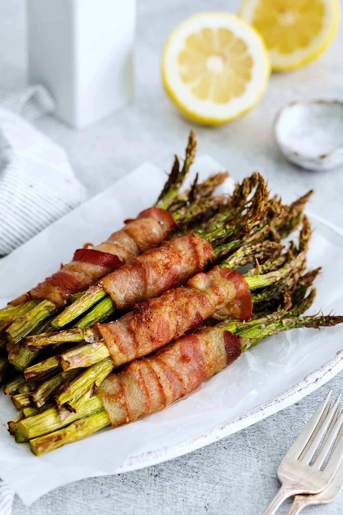 Bundles of bacon wrapped asparagus on a plate