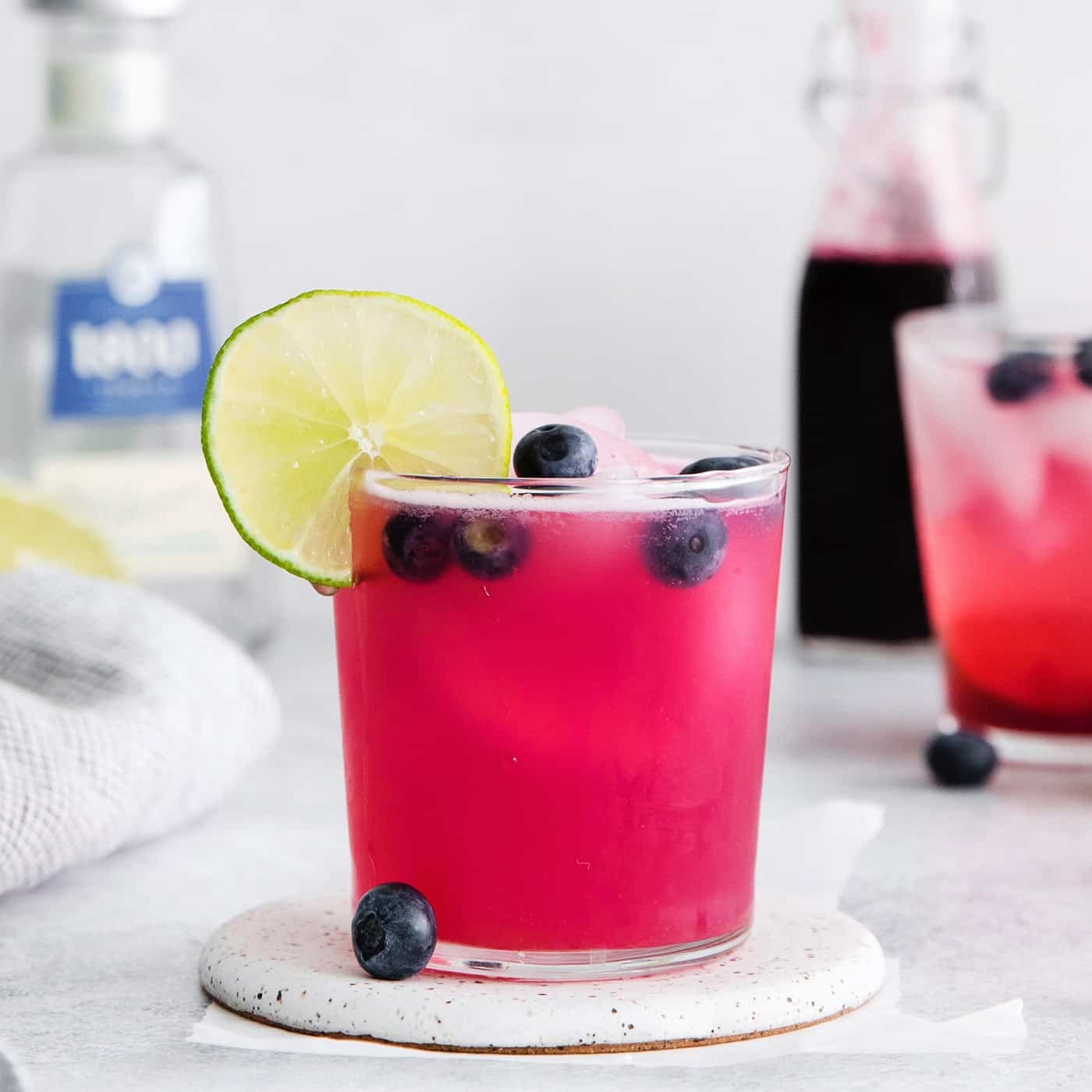 A blueberry margarita garnished with a lime slice