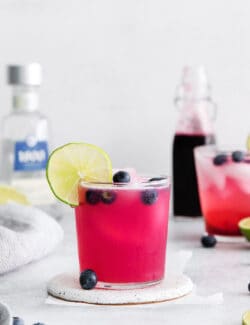 A blueberry margarita garnished with a lime slice