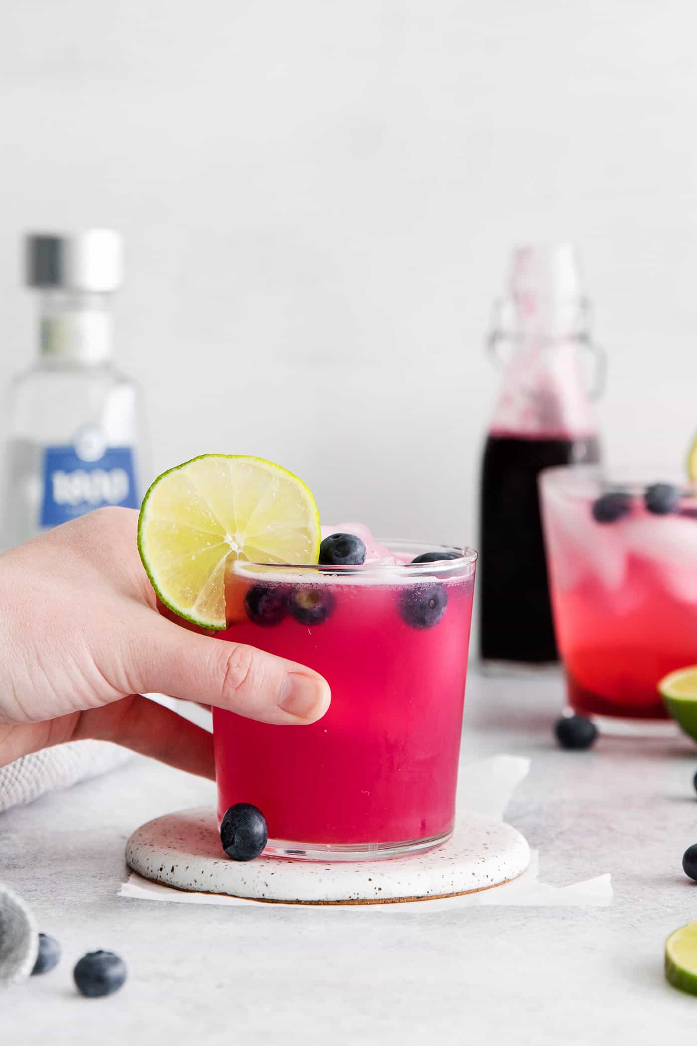 A hand holding a blueberry margarita