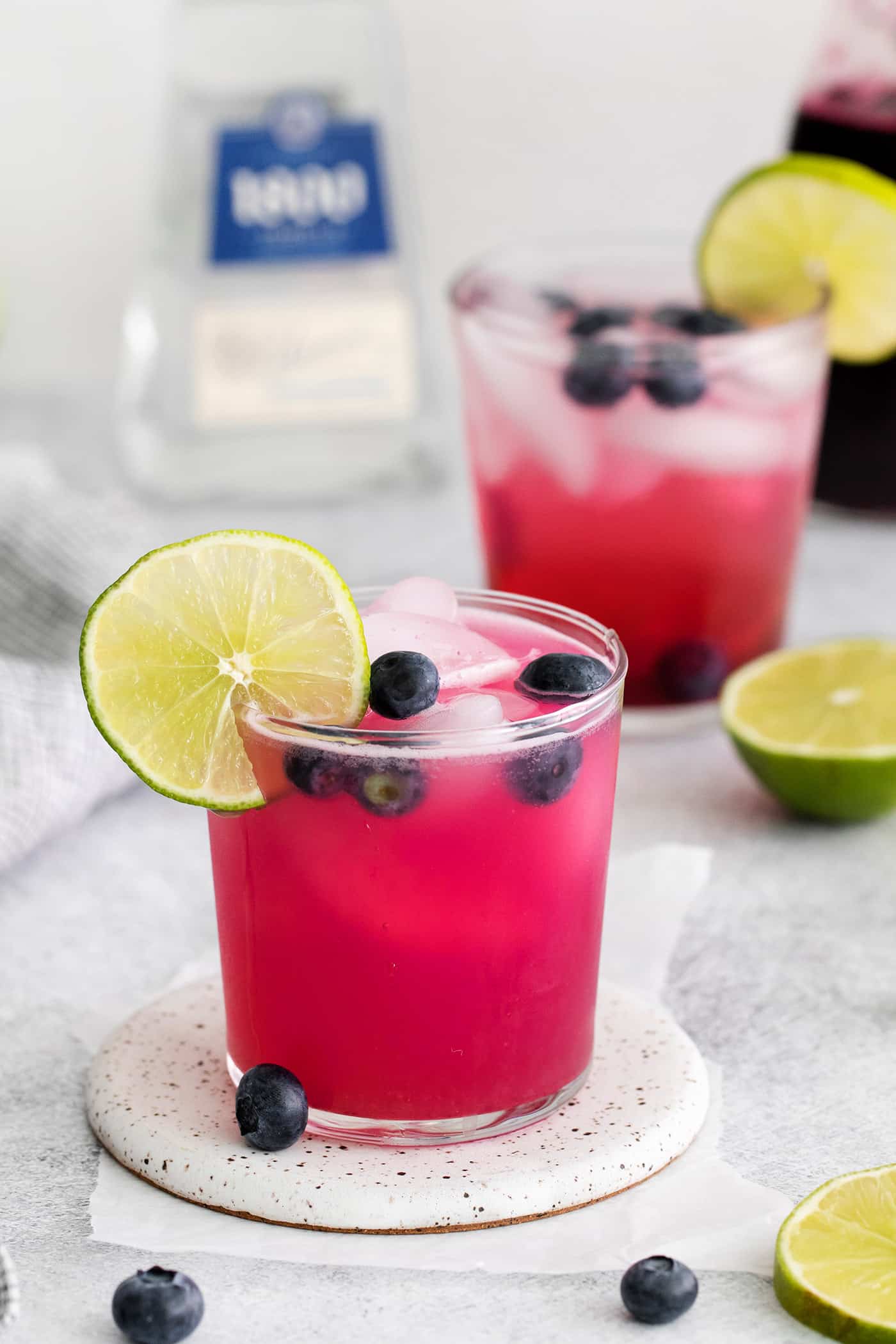 Angled view of a blueberry margarita with a lime slice