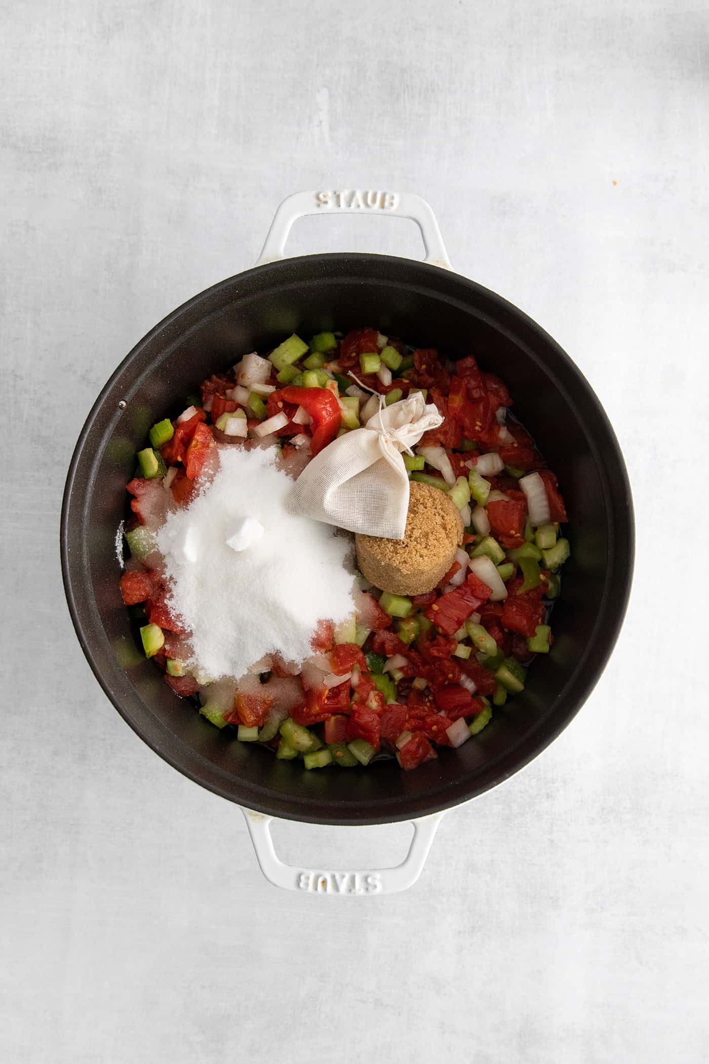 Tomatoes, diced veggies, sugar, and pickling spices in a pot