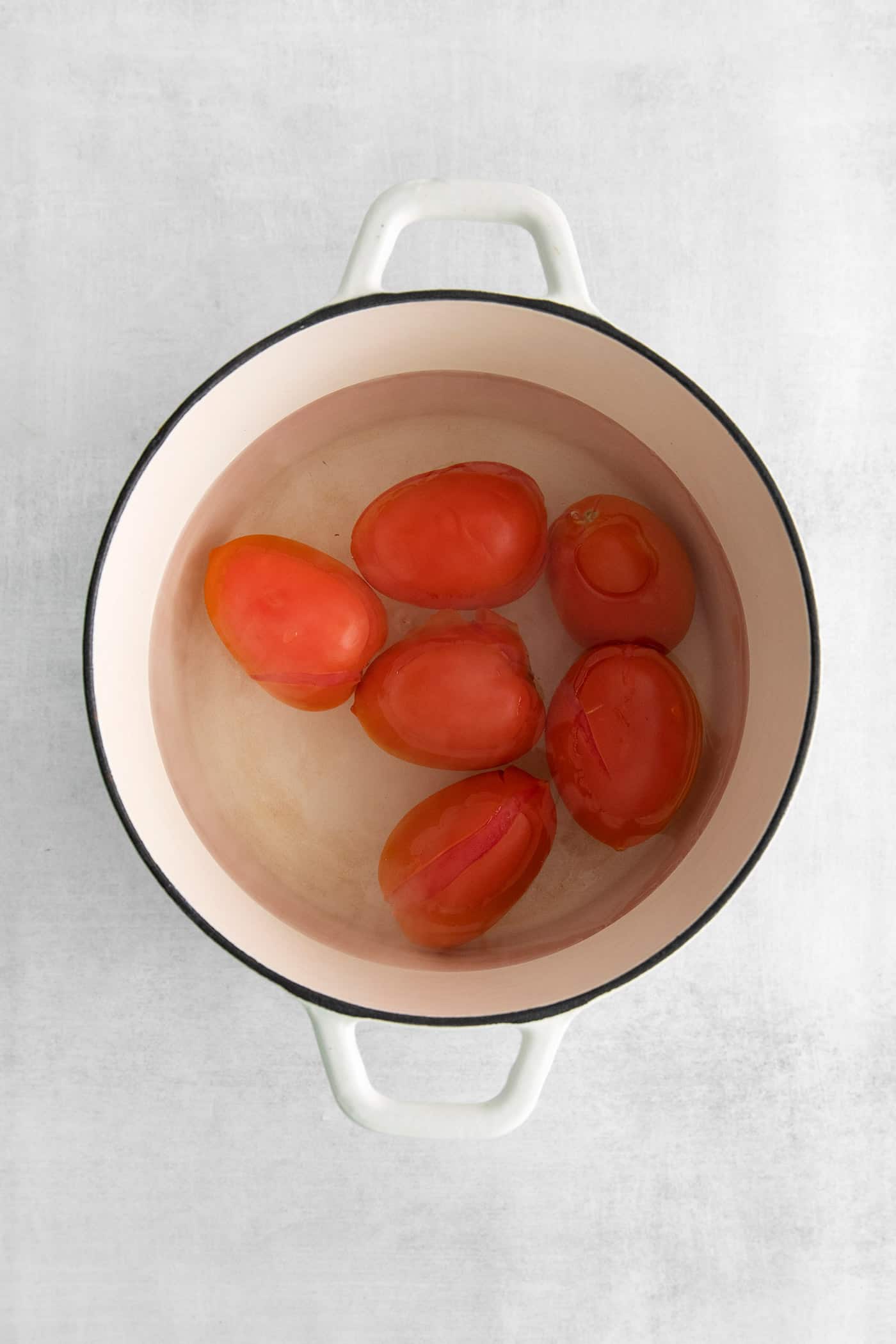 Roma tomatoes in a pot of water