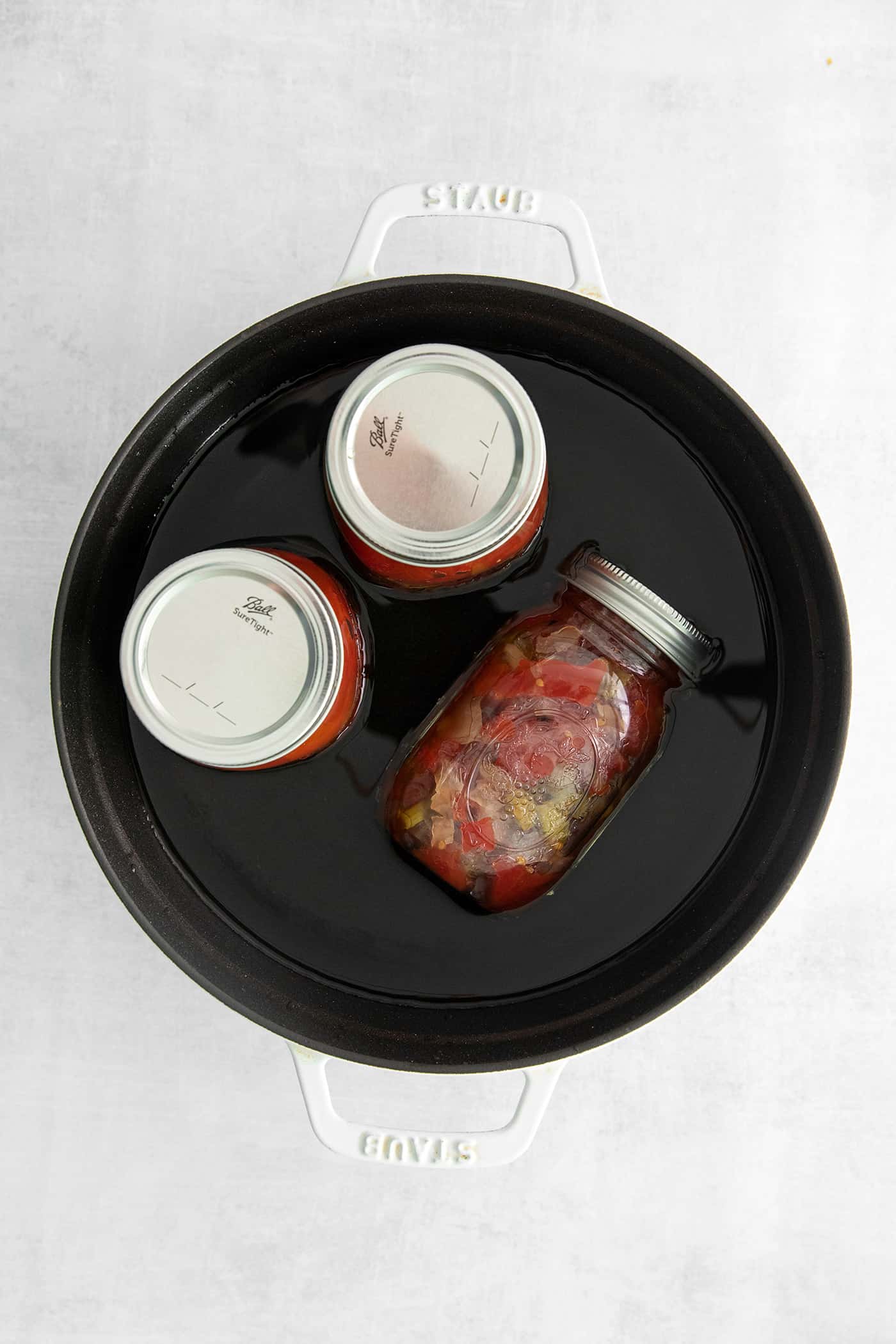 Jars of stewed tomatoes in a water bath