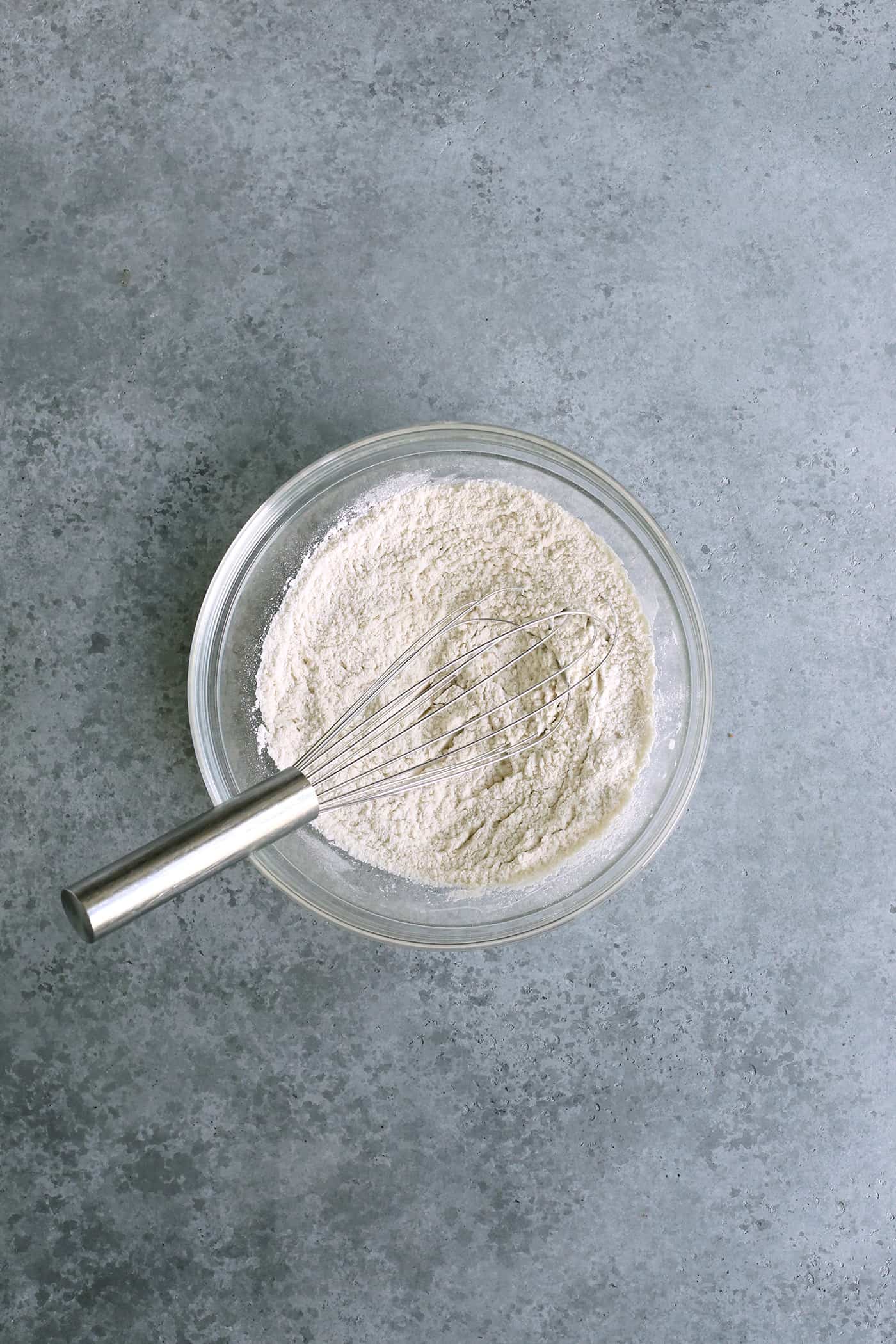 dry ingredients in a clear bowl with a whisk