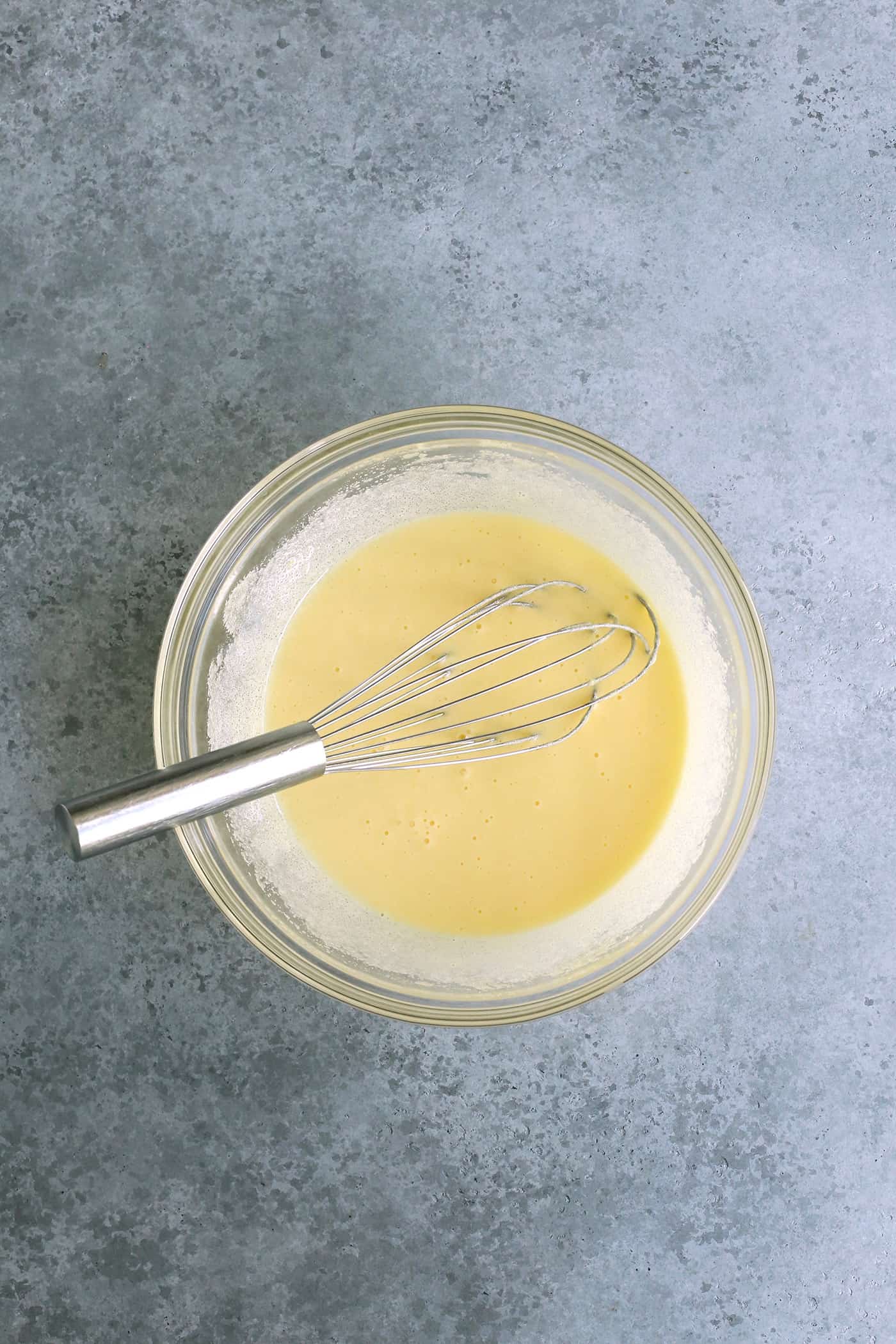 wet ingredients in a clear bowl with a whisk