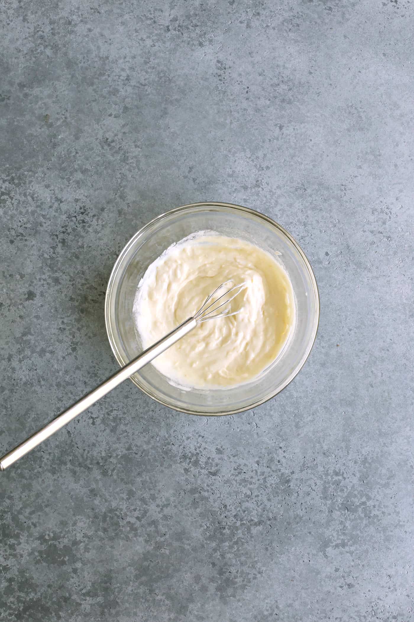 whisking butter, sour cream, and lemon zest in a clear bowl