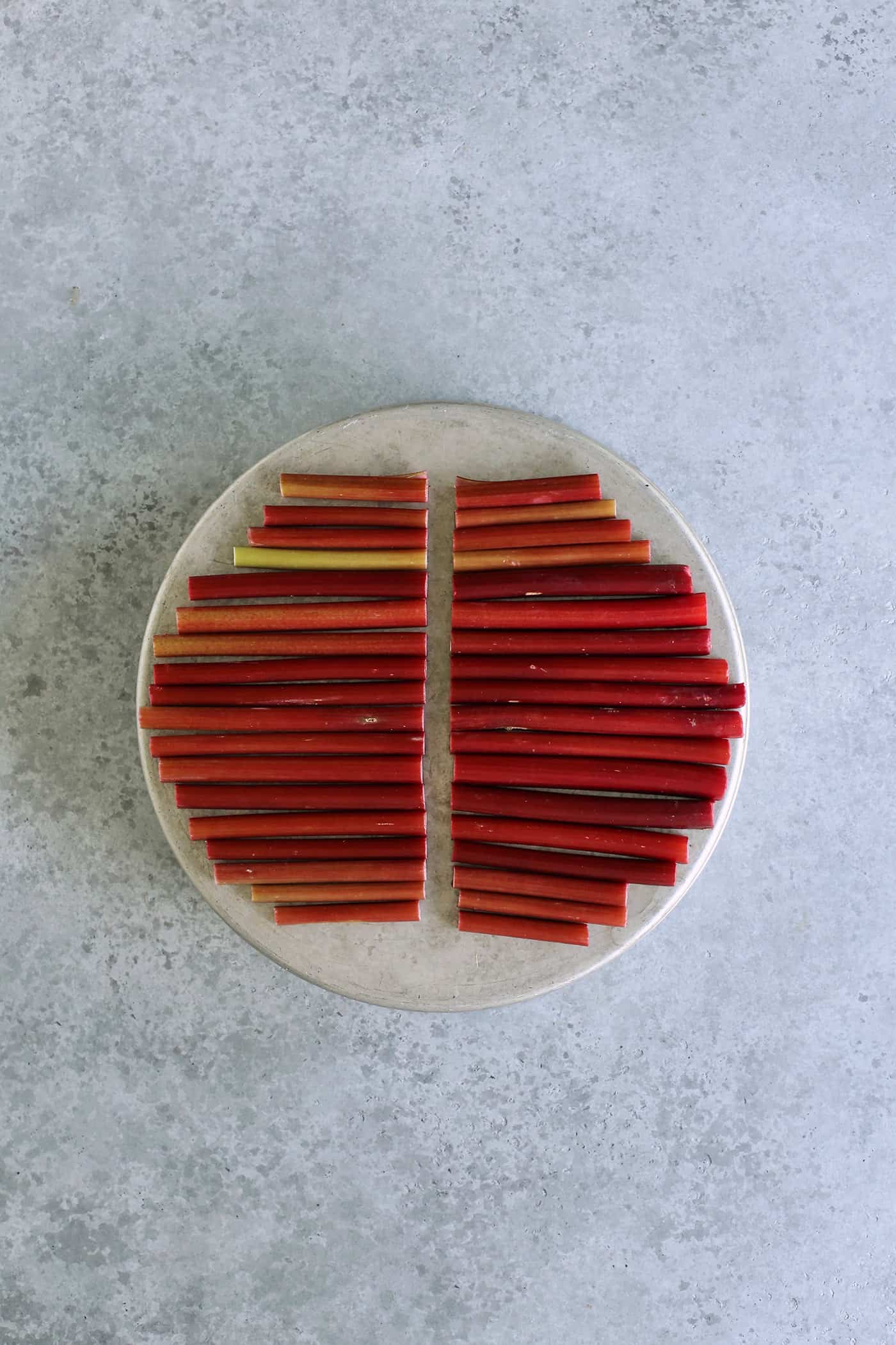rhubarb lined up on a round cake pan, then cut in half