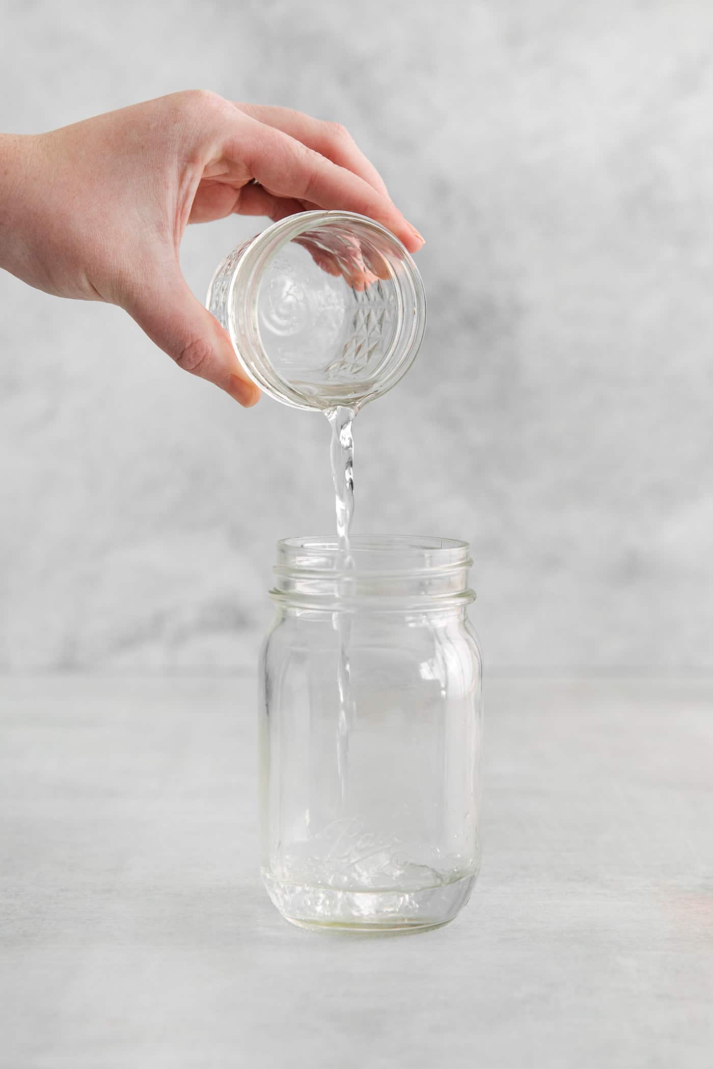 pouring tequila into a jar