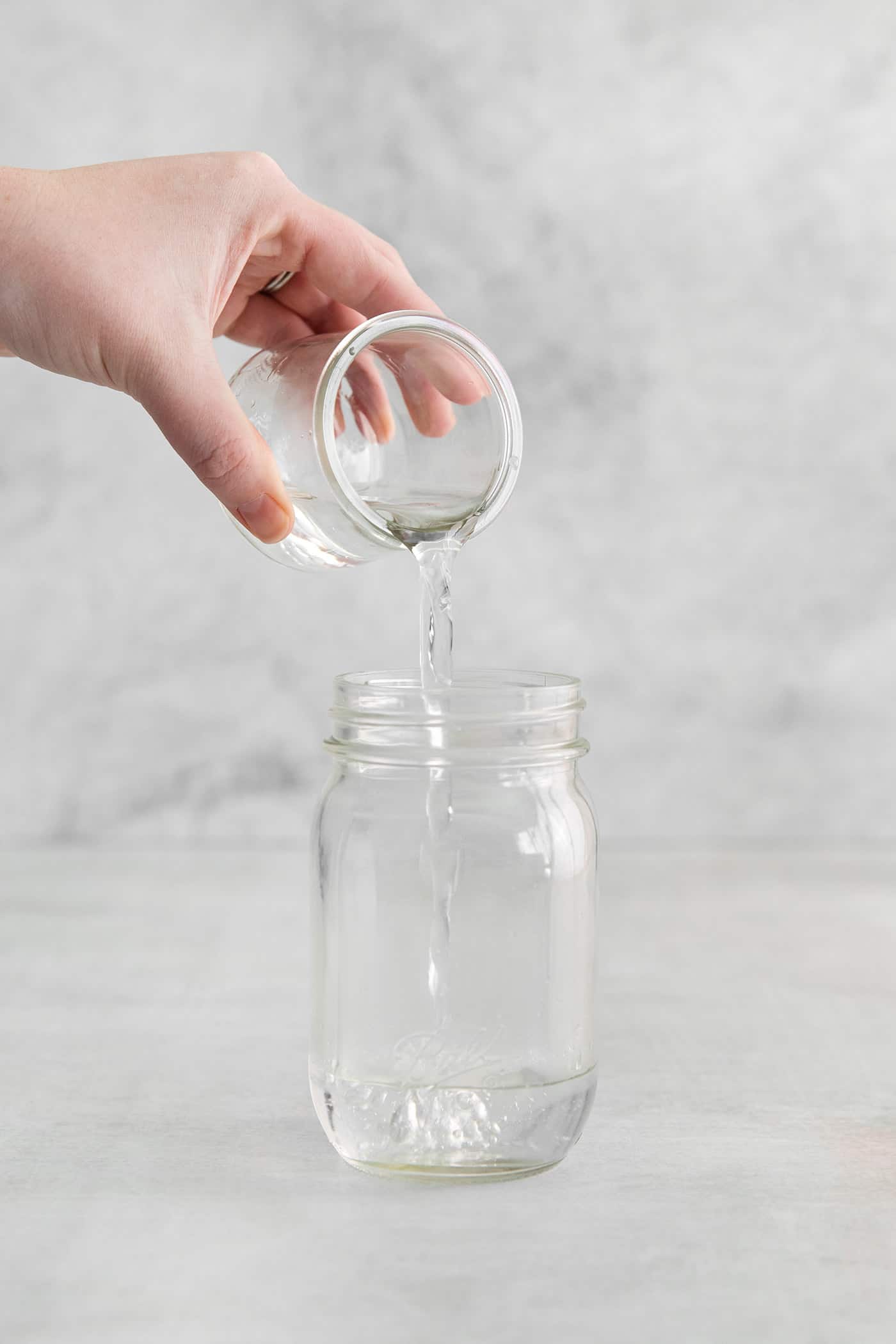 pouring orange liqueur into a jar