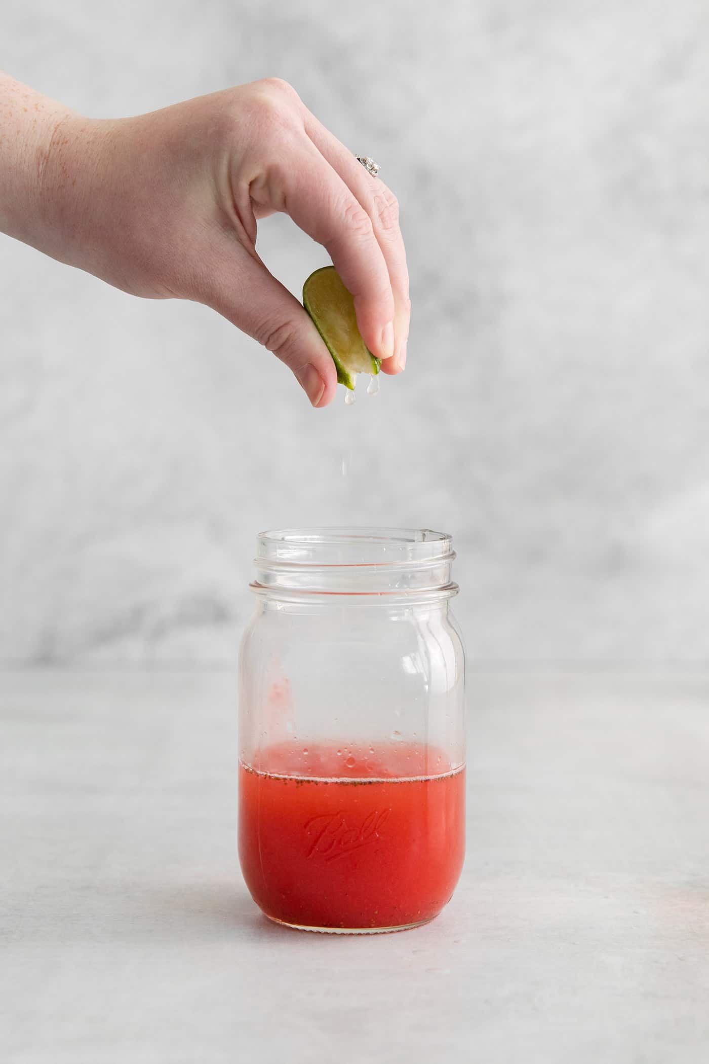 squeezing lime juice into a jar