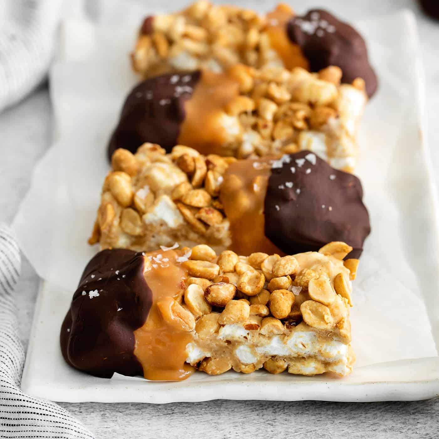 chocolate dipped salted nut rolls on a white plate