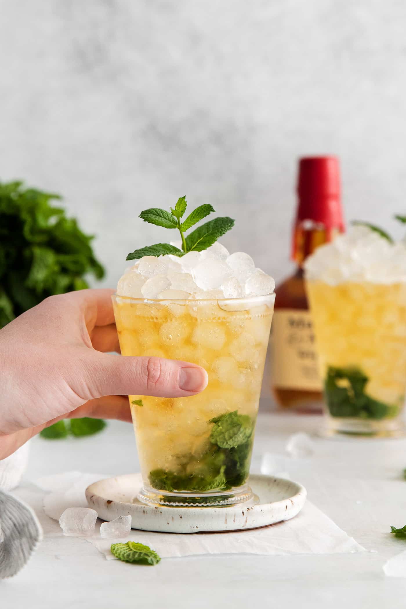 A hand grabbing a mint julep cocktail