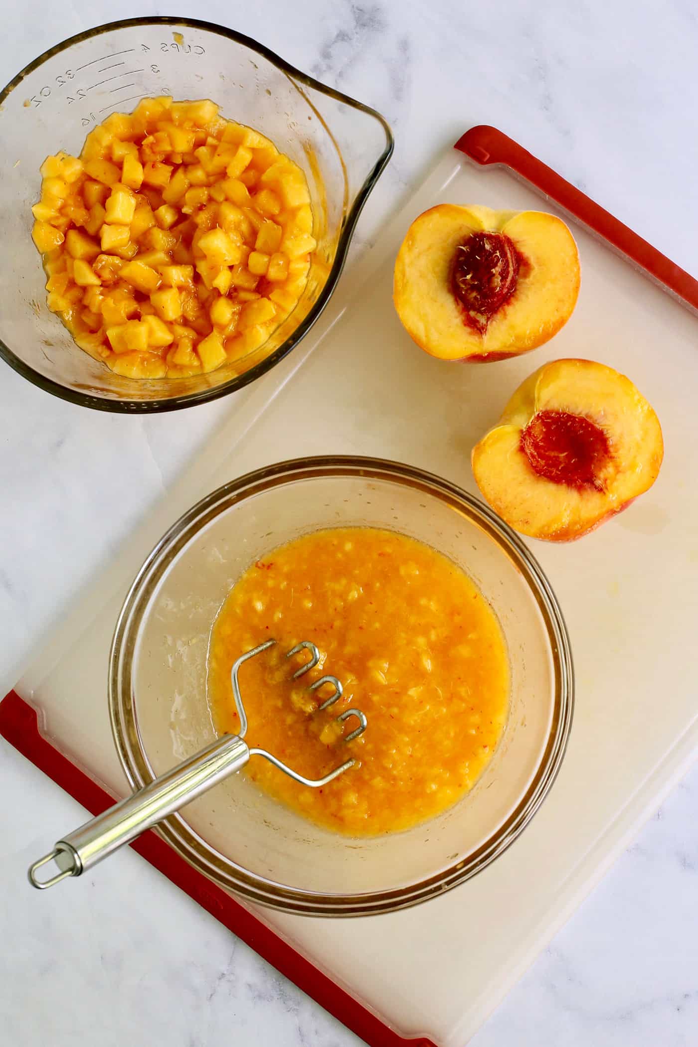 using a potato masher to mash fresh peaches