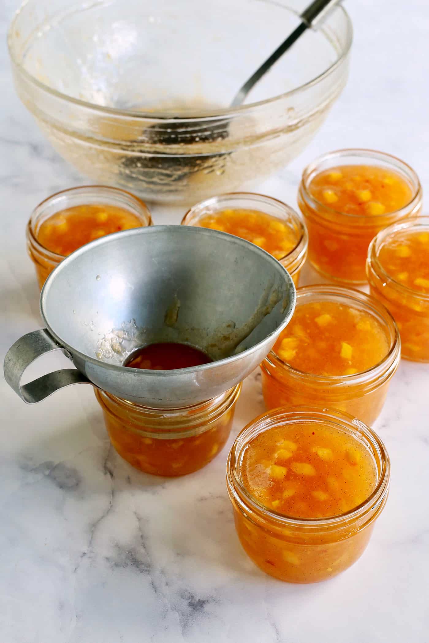transferring peach jam mixture to individual canning jars