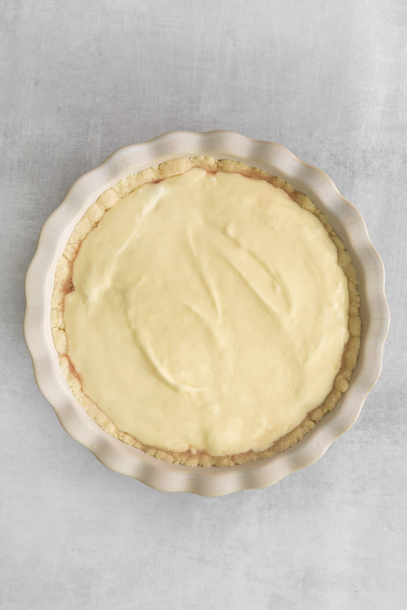 cheesecake layer spread over the rhubarb, in the pie plate