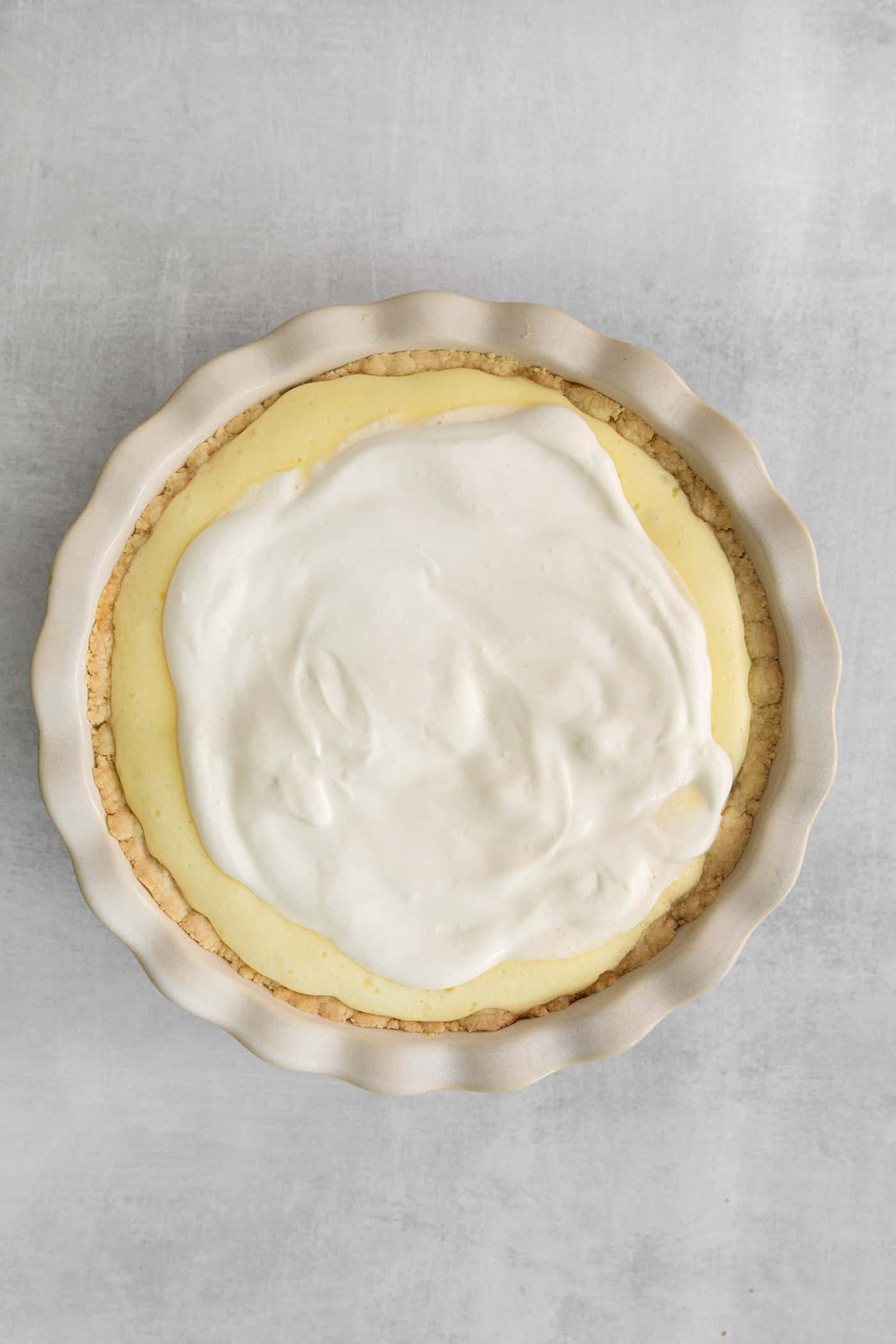 sour cream layer spread over cheesecake layer on pie